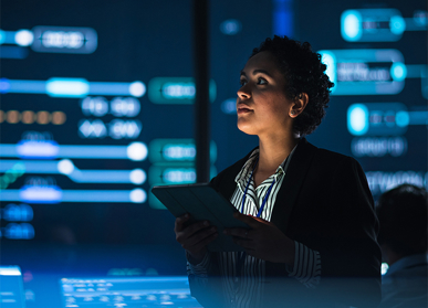 Woman working on tablet device with code background