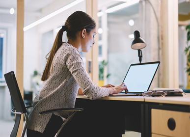 Female employee working at desk on laptop